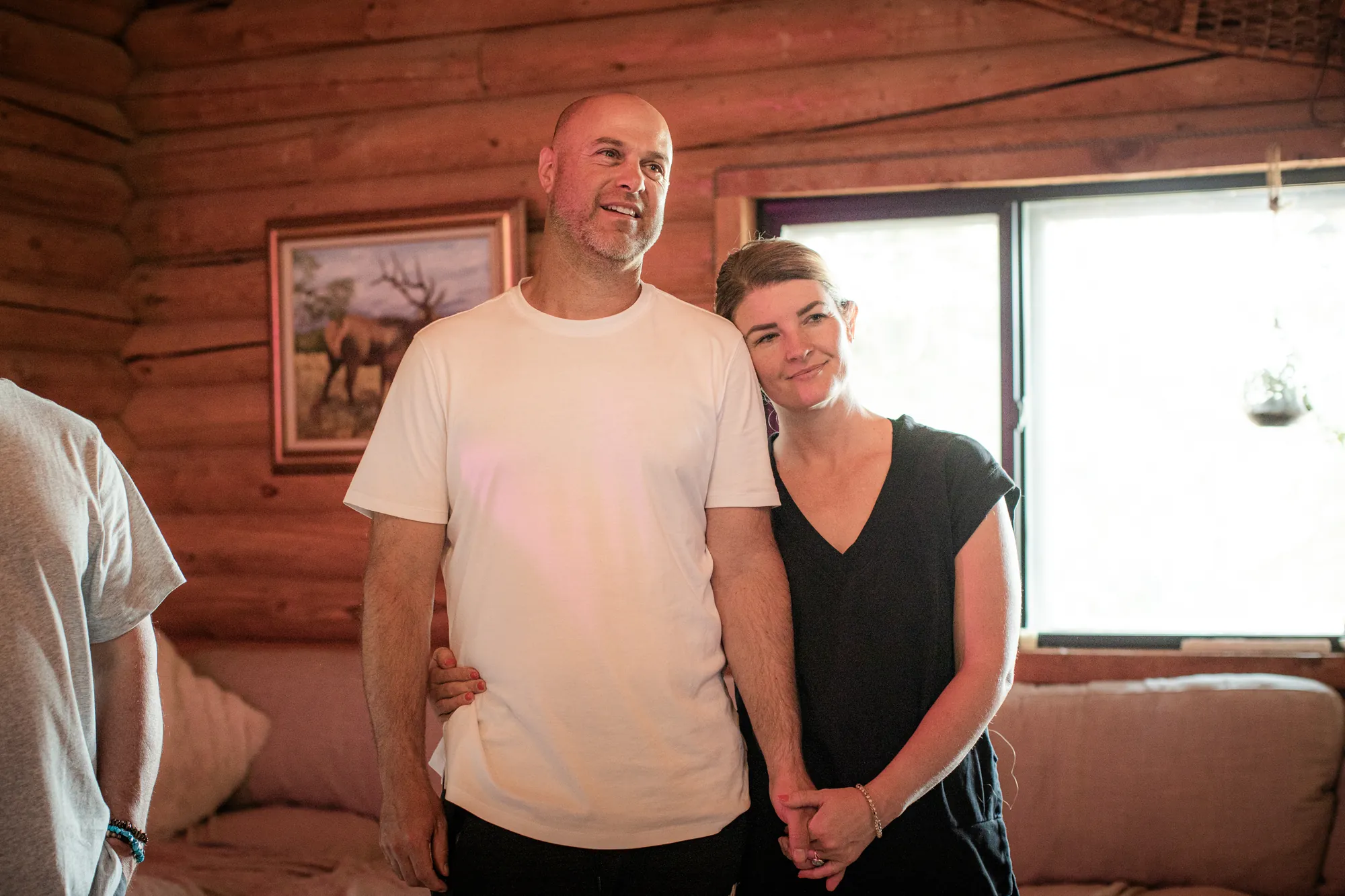 A man and a woman standing together in a wooden retreat cabin